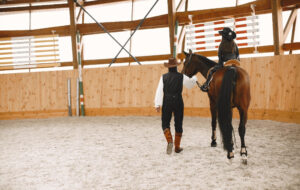 Two people standing in a horse arena